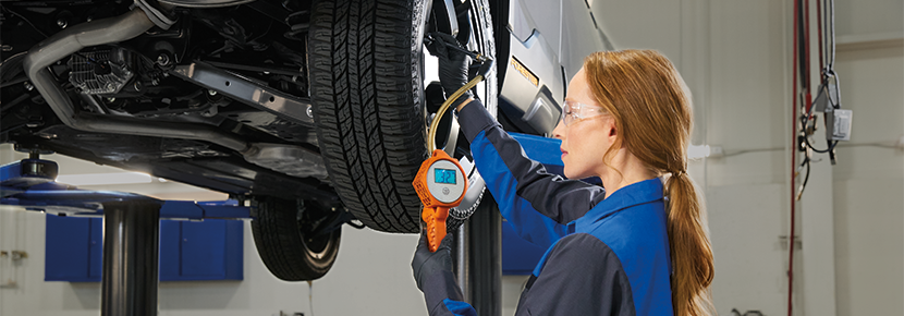 A Subaru technician checking tire pressure. | Hanania Subaru of Orange Park in Jacksonville FL