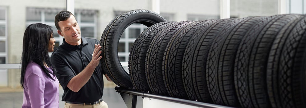 Subaru service representative showing customer a tire. | Hanania Subaru of Orange Park in Jacksonville FL