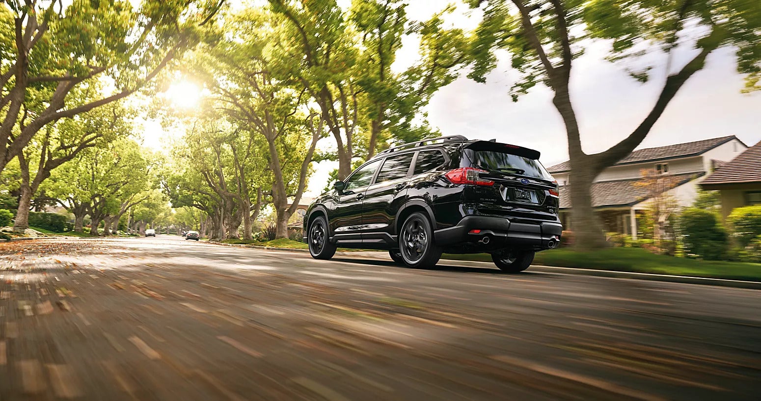 a black subaru ascent driving in a suburb