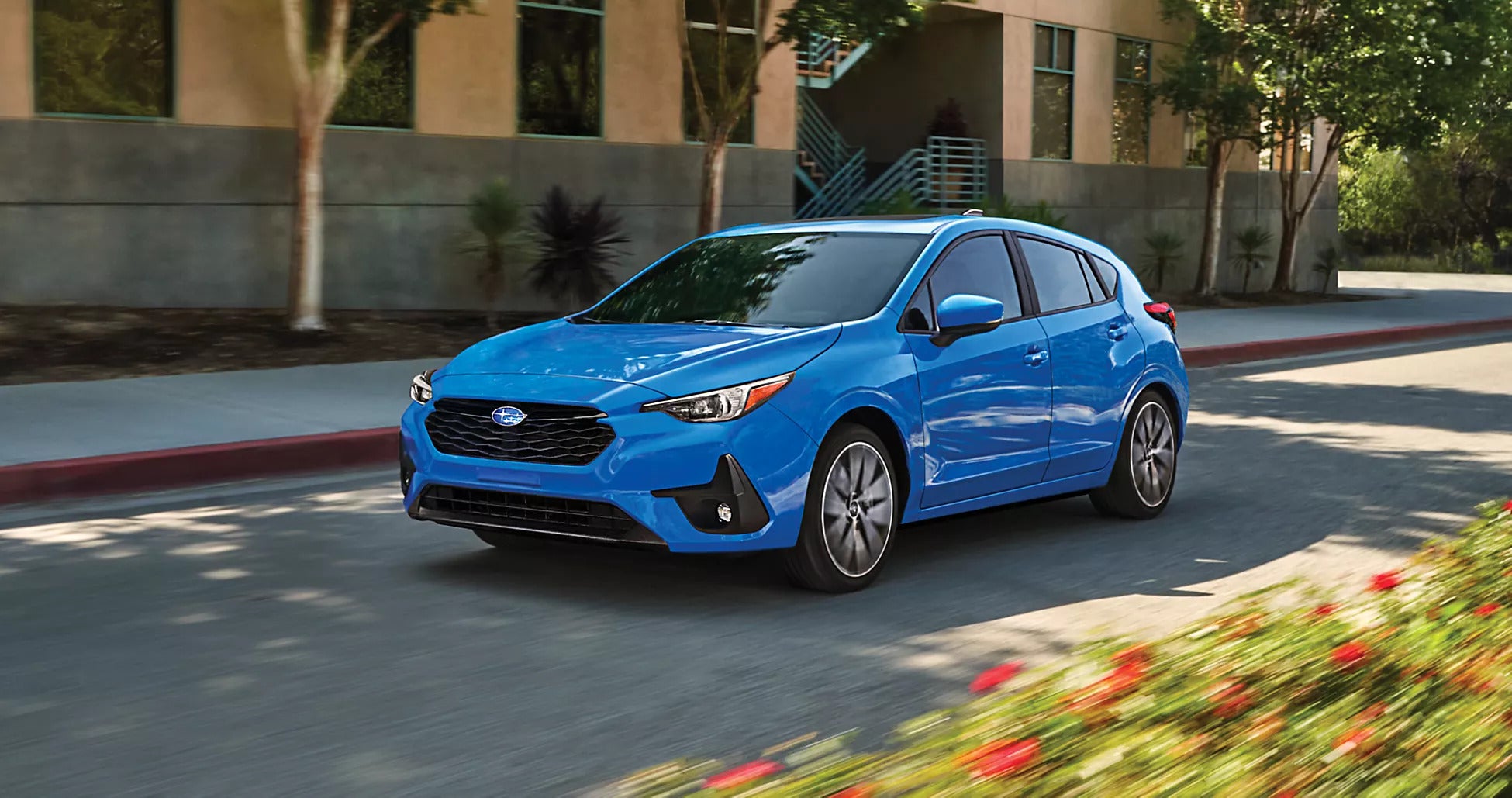 A blue car driving on the road.