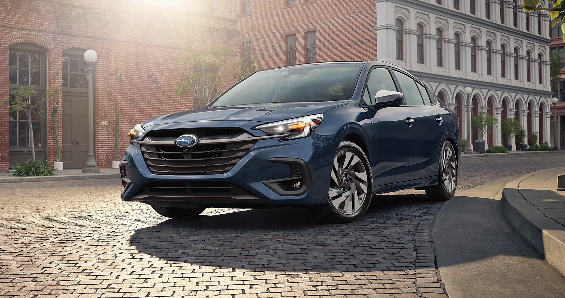 A blue car sitting parked in the road.