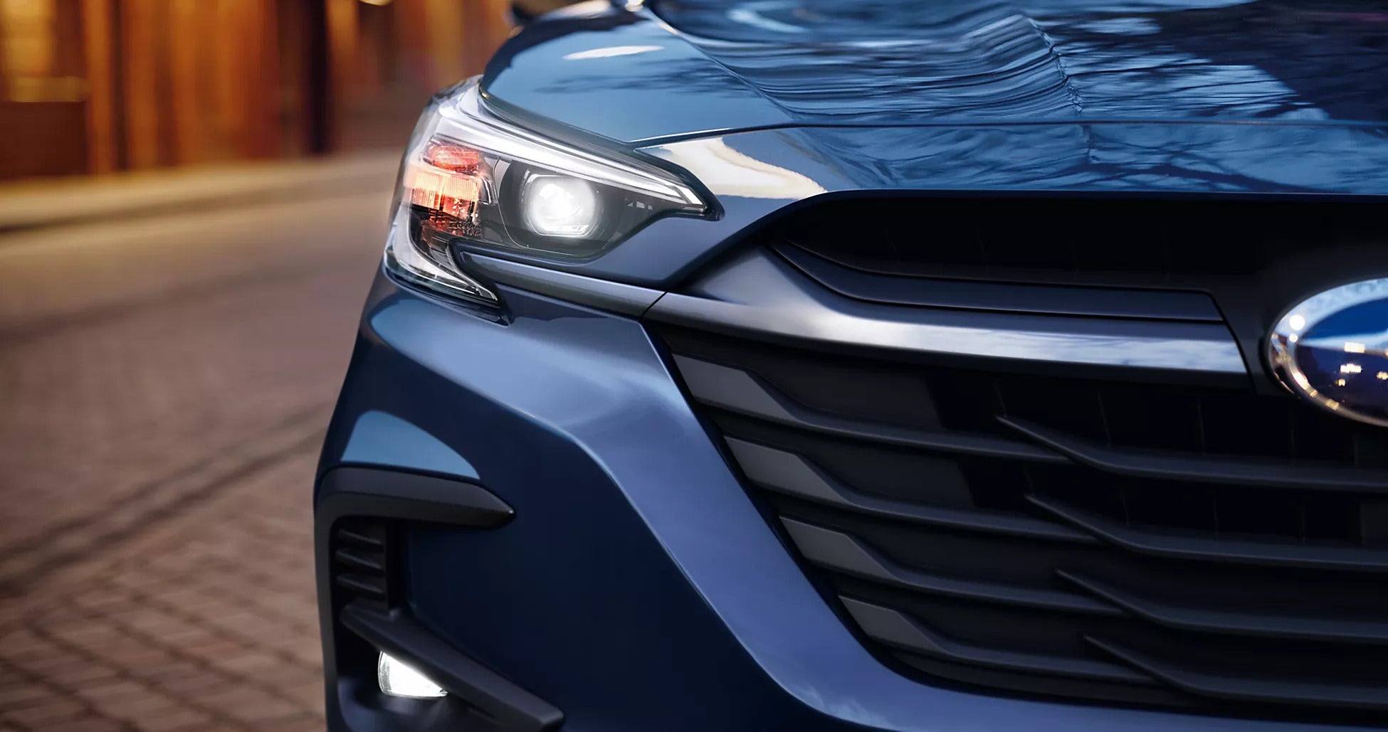 A close look at the front of a blue car.