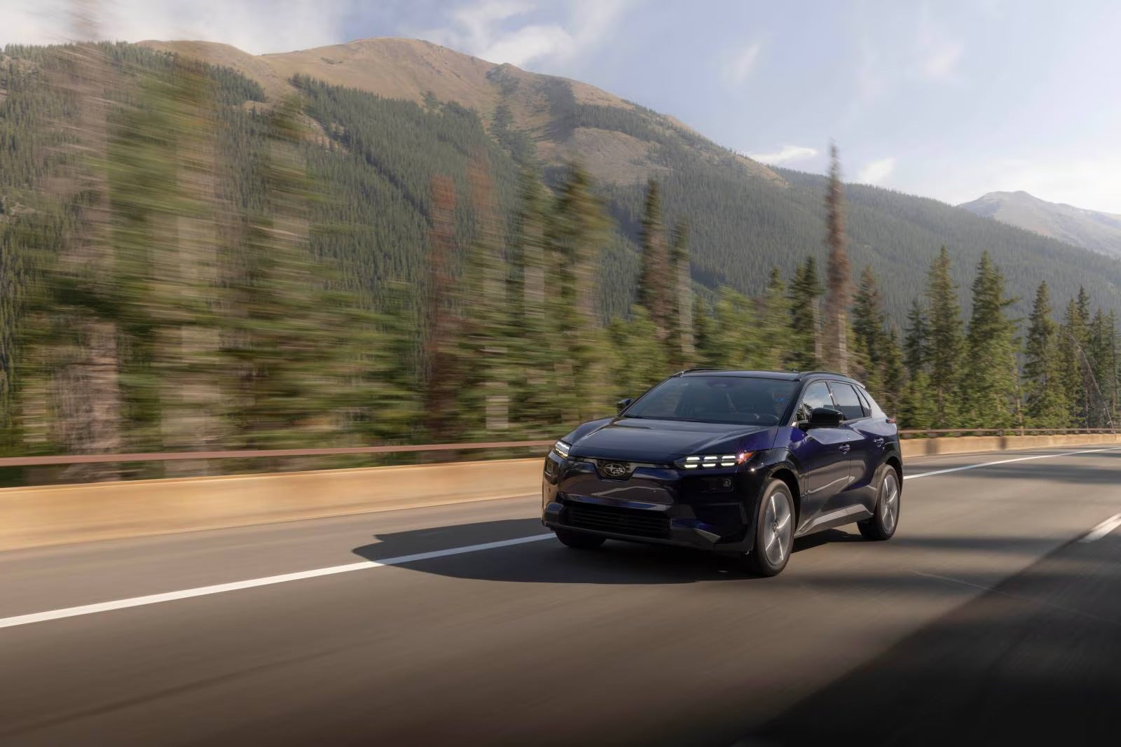 A blue car driving on the road.